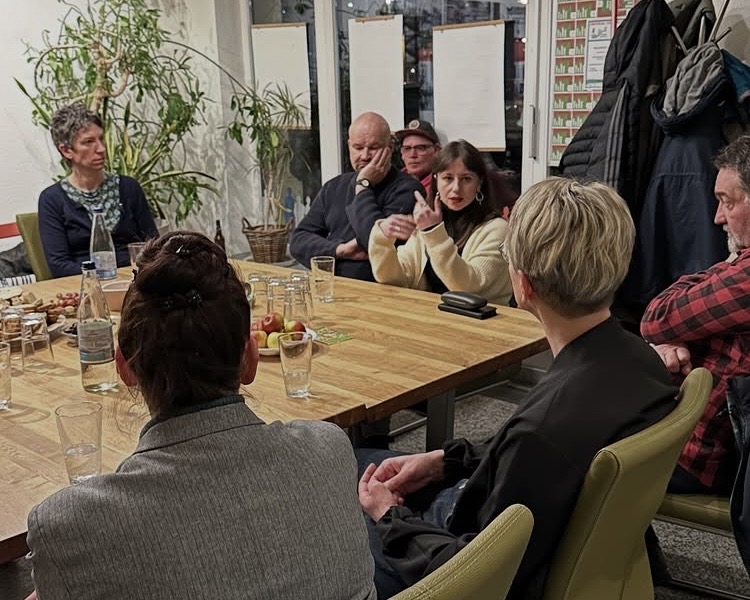 Sophia Bauer erläutert ihren Standpunkt. Nathalie Senf, Wolfgang Wetzel und weitere Gäste hören ihr aufmerksam zu.